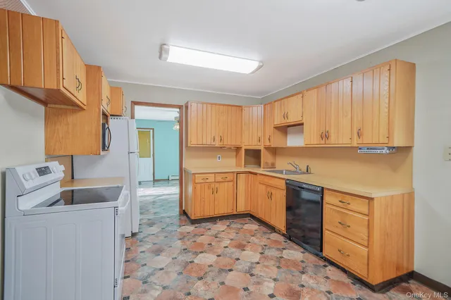 a kitchen with a sink a stove cabinets and wooden floor