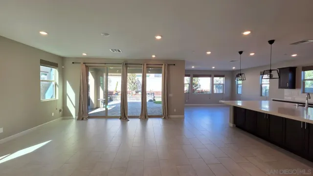 a kitchen with stainless steel appliances kitchen island granite countertop a refrigerator a sink a stove and a wooden cabinets with wooden floor