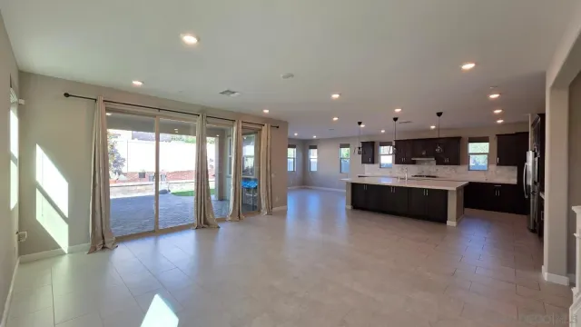 a large kitchen with kitchen island a large counter top a sink and stainless steel appliances