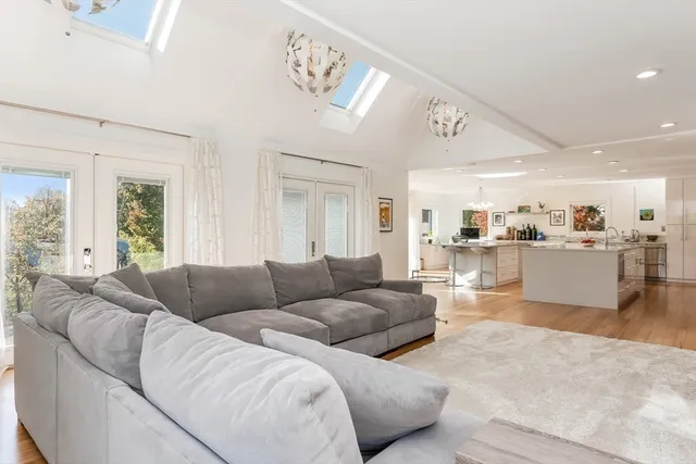 a living room with furniture and view of kitchen