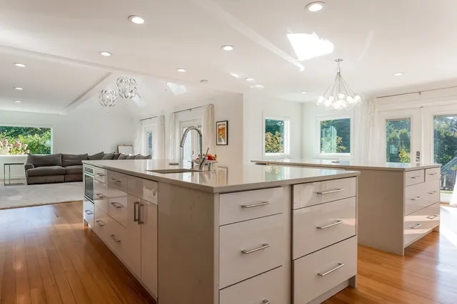 a large kitchen with cabinets wooden floor and stainless steel appliances