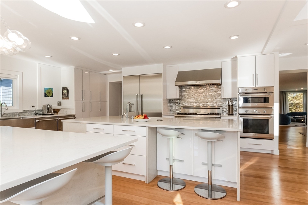 2-4 Evergreen Avenue Newton, MA 02466 - Photo 17 of 41 a kitchen with stainless steel appliances kitchen island granite countertop a stove a sink a refrigerator and white cabinets with wooden floor