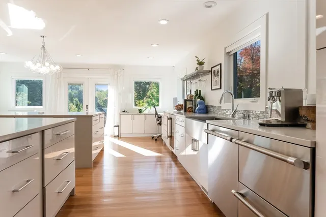 a kitchen with white cabinets and sink