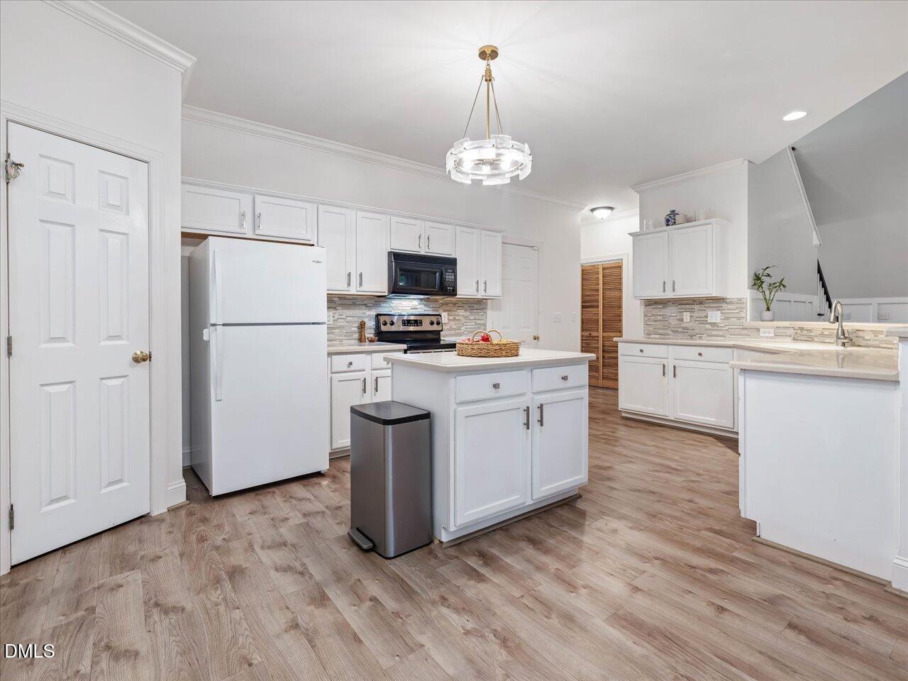 1311 Pendula Path Apex, NC 27502 - Photo 11 of 30 a kitchen with kitchen island granite countertop stainless steel appliances a stove a sink cabinets and a refrigerator