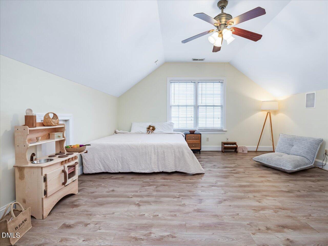 1311 Pendula Path Apex, NC 27502 - Photo 17 of 30 a spacious bedroom with a bed a chandelier and a couch