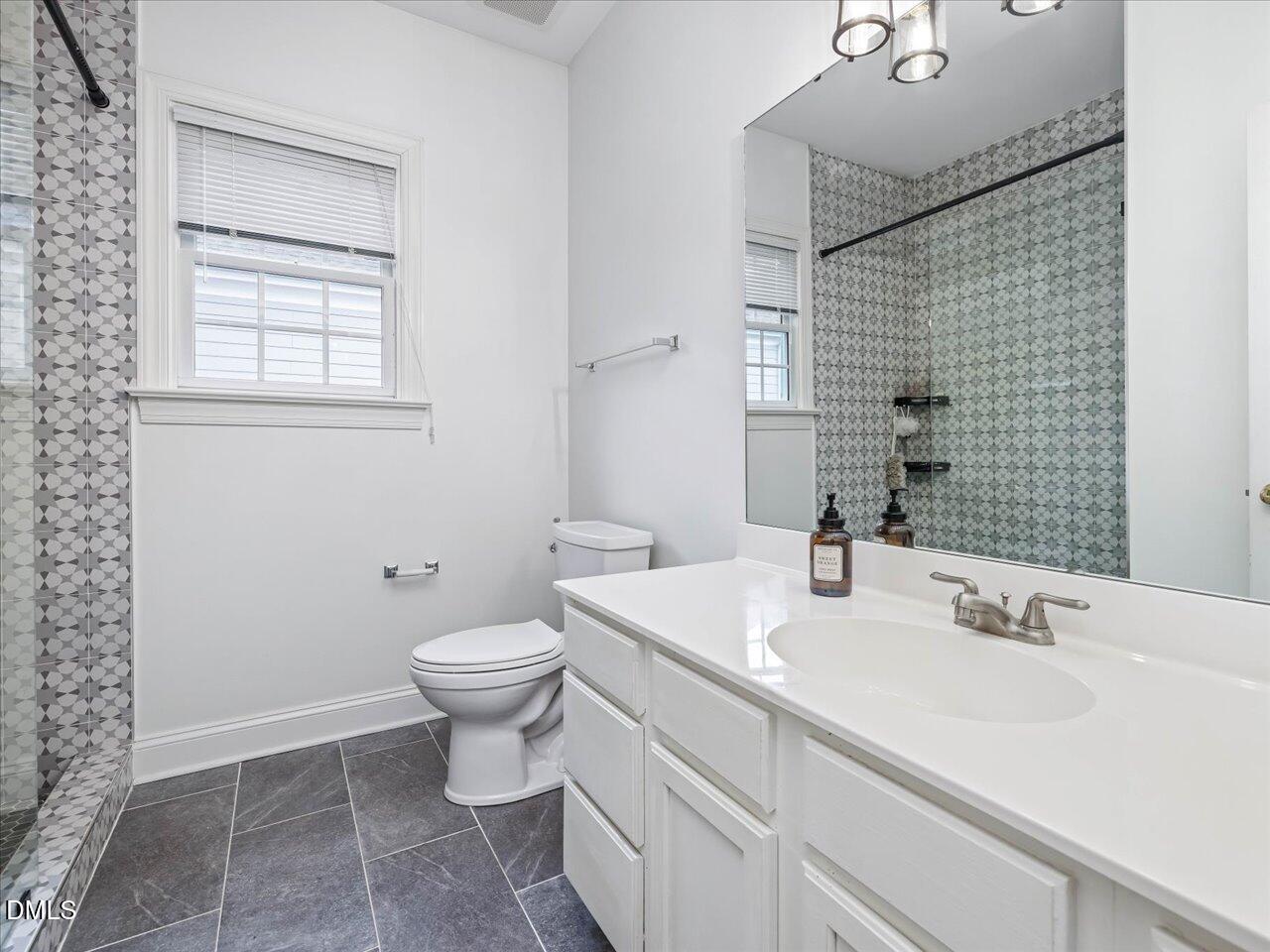 1311 Pendula Path Apex, NC 27502 - Photo 19 of 30 a bathroom with a sink a toilet and mirror