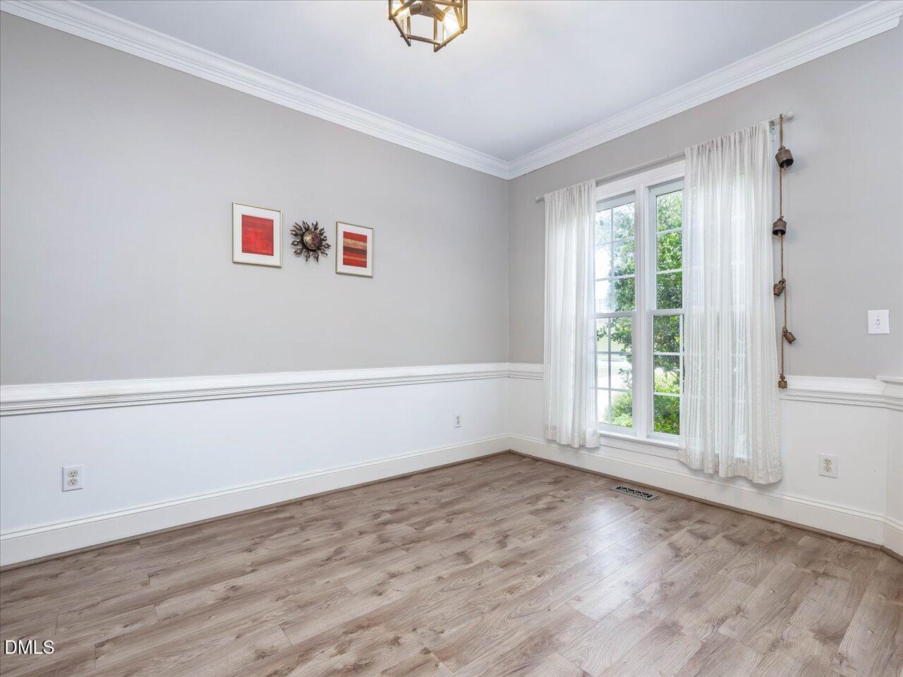 1311 Pendula Path Apex, NC 27502 - Photo 8 of 30 an empty room with wooden floor and windows