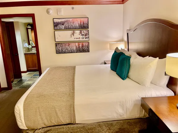 a bed sitting in a bedroom and painting on the wall