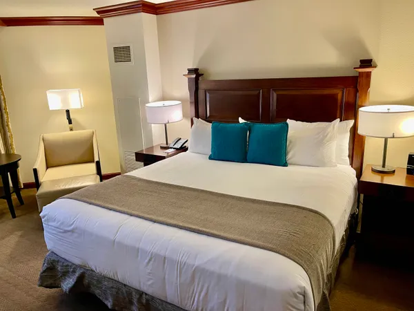 a large bed sitting in a bedroom next to a lamp