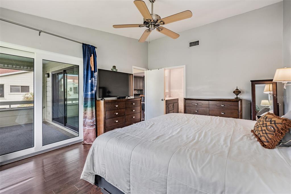 637 Drake Lane North Dunedin, FL 34698 - Photo 17 of 43 a large bedroom with a bed and a flat tv screen on dresser