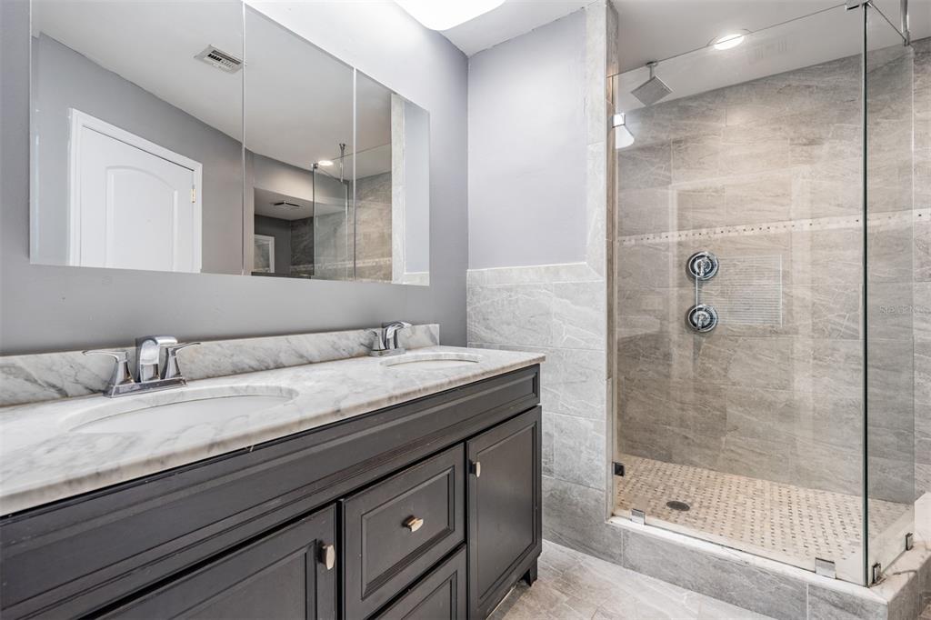 637 Drake Lane North Dunedin, FL 34698 - Photo 18 of 43 a bathroom with a granite countertop sink a mirror and a bathtub