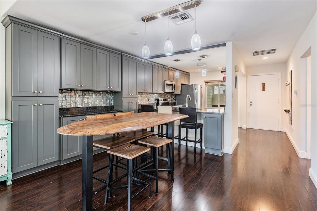 637 Drake Lane North Dunedin, FL 34698 - Photo 3 of 43 a kitchen with stainless steel appliances kitchen island granite countertop a table chairs and a refrigerator