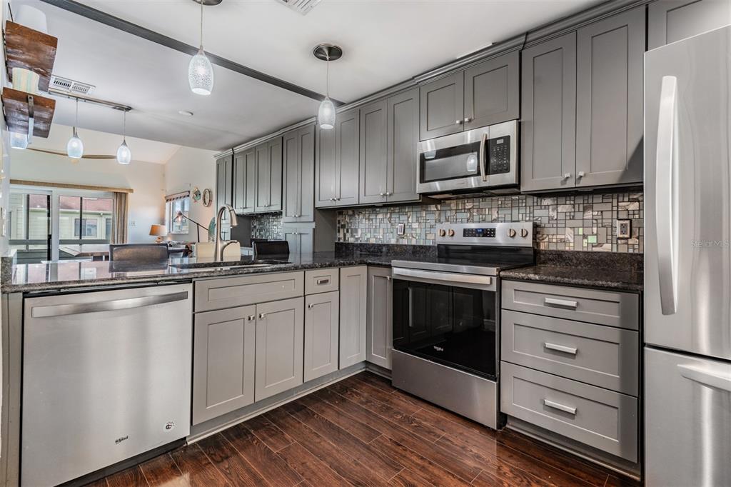 637 Drake Lane North Dunedin, FL 34698 - Photo 6 of 43 a kitchen with granite countertop white cabinets stainless steel appliances and a sink