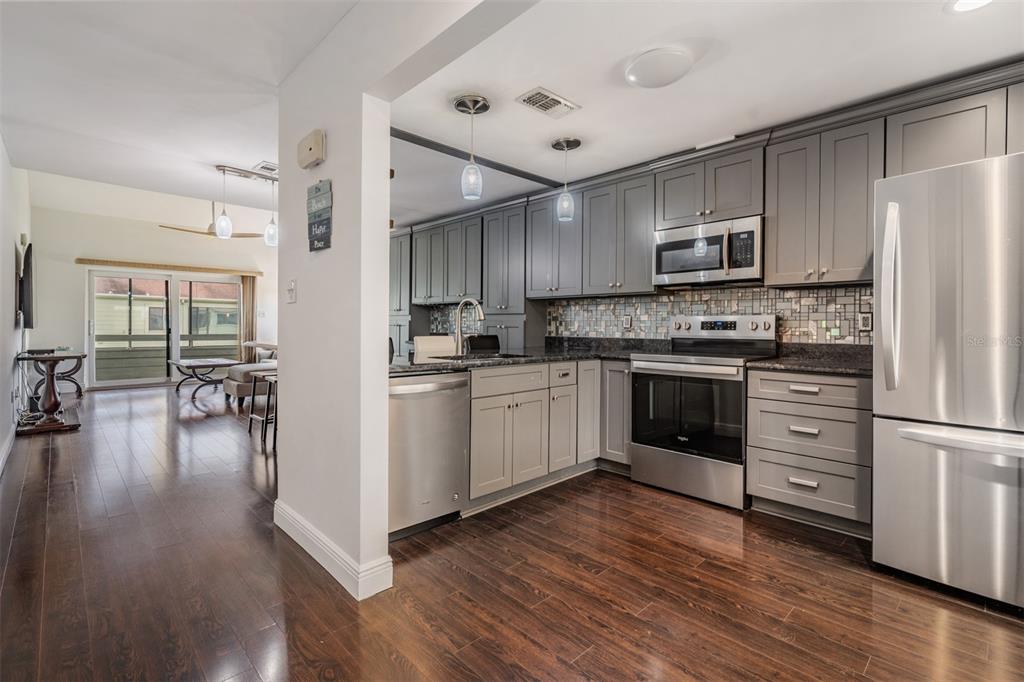 637 Drake Lane North Dunedin, FL 34698 - Photo 8 of 43 a kitchen with cabinets wooden floor and stainless steel appliances