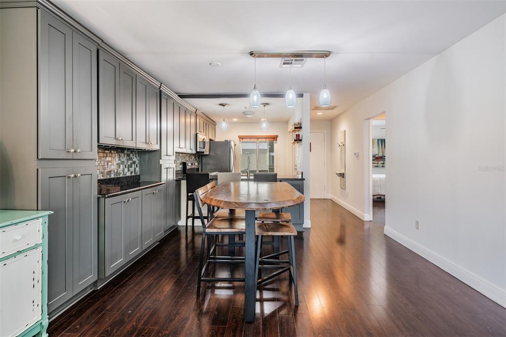 637 Drake Lane North Dunedin, FL 34698 - Photo 9 of 43 a kitchen with stainless steel appliances kitchen island granite countertop a table chairs and a refrigerator