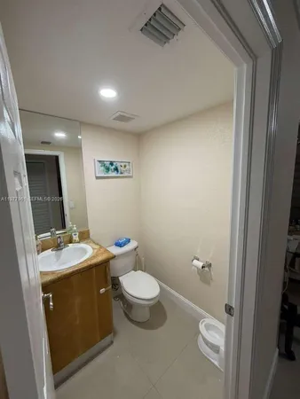 a bathroom with a granite countertop sink toilet and mirror