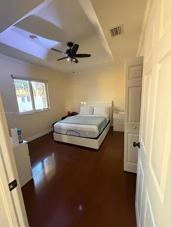 a bedroom with a bed and wooden floor