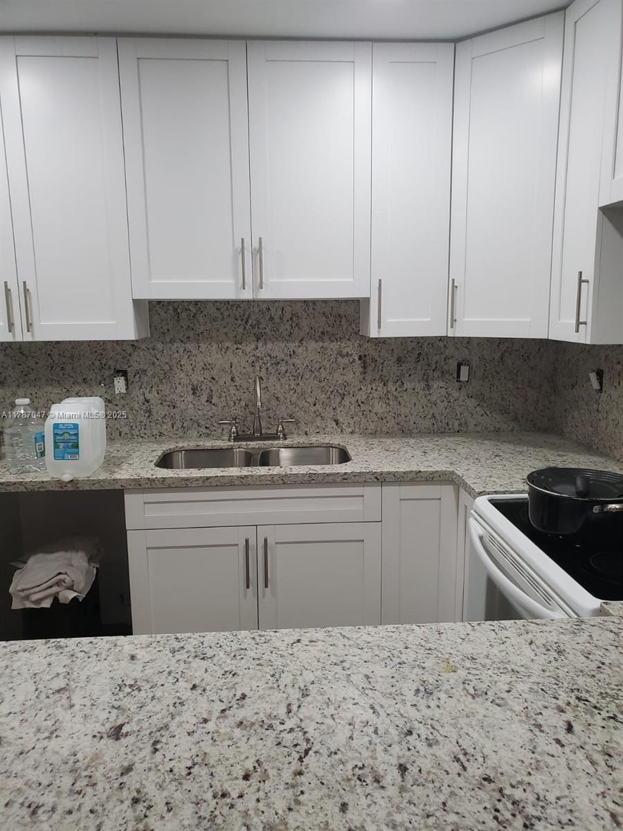 13745 Southwest 84th Street, Unit A Miami, FL 33143 - Photo 4 of 16 a kitchen with granite countertop a sink and cabinets