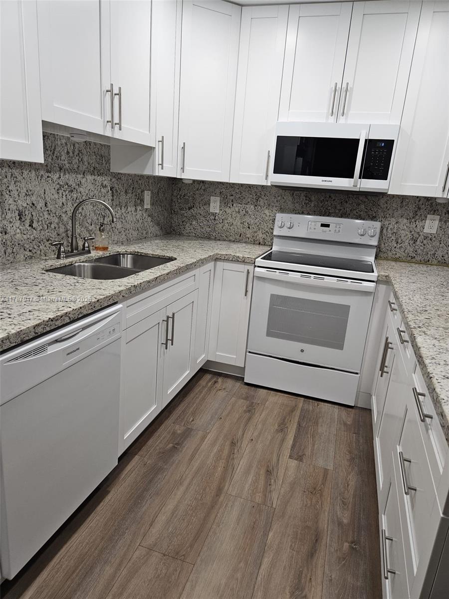 13745 Southwest 84th Street, Unit A Miami, FL 33143 - Photo 5 of 16 a kitchen with a sink stove and cabinets