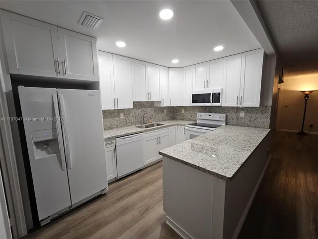 a kitchen with a refrigerator a sink and cabinets