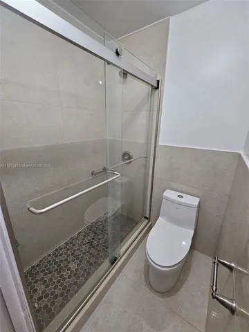 a bathroom with a toilet and a shower