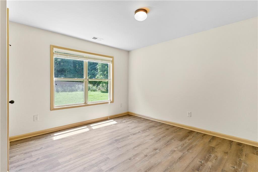 1492 Station Ridge Court Southeast Lawrenceville, GA 30045 - Photo 15 of 50 an empty room with wooden floor and windows