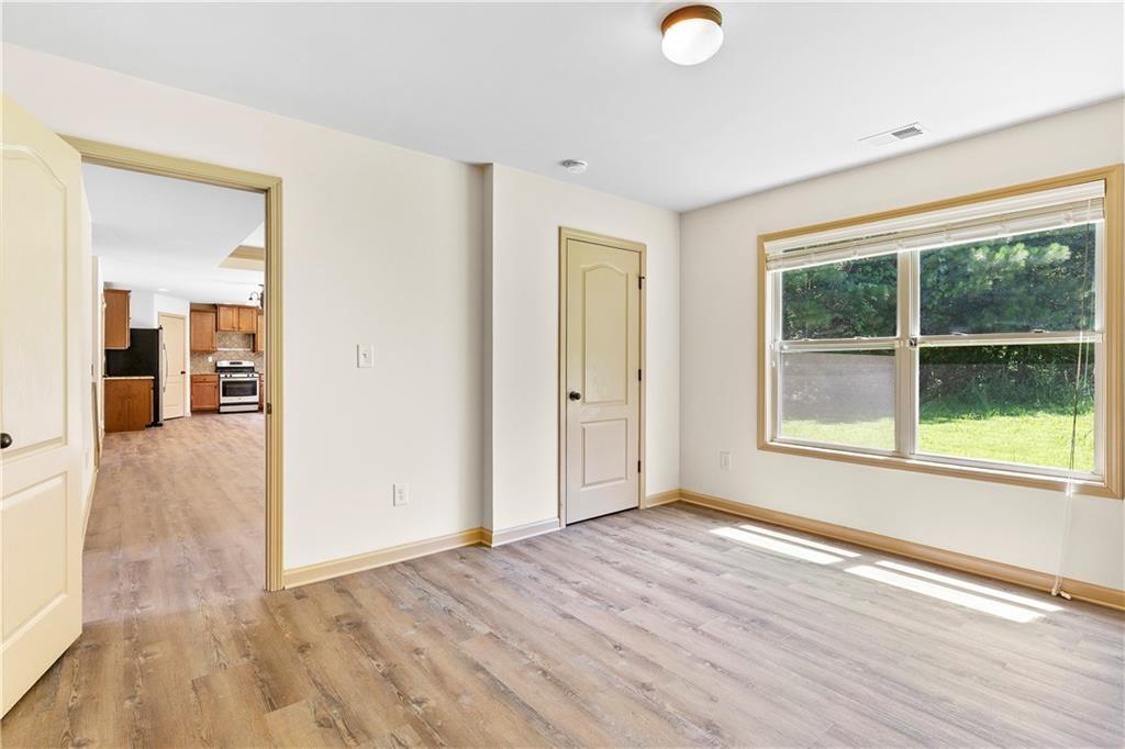 1492 Station Ridge Court Southeast Lawrenceville, GA 30045 - Photo 16 of 50 an empty room with wooden floor and windows