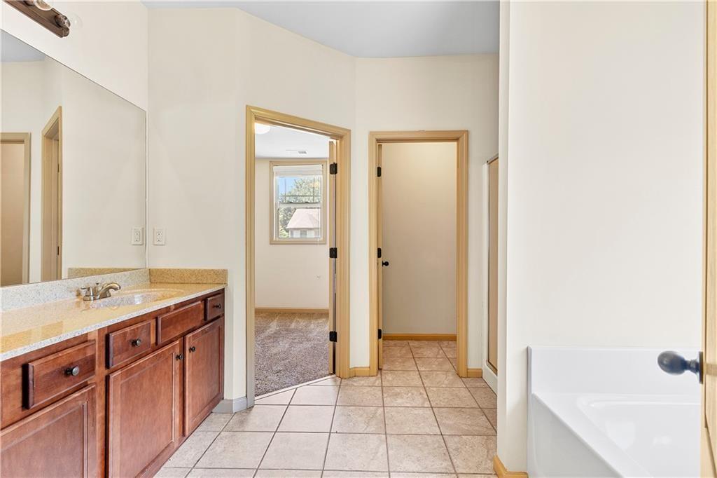 1492 Station Ridge Court Southeast Lawrenceville, GA 30045 - Photo 41 of 50 a spacious bathroom with a granite countertop sink a mirror and a bathtub