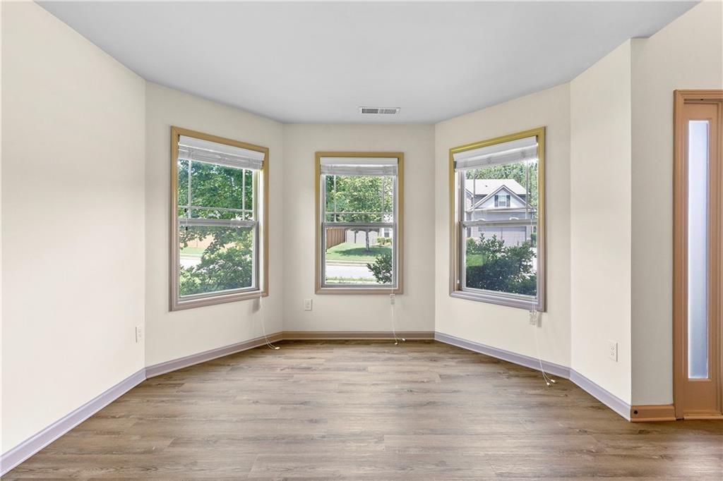 1492 Station Ridge Court Southeast Lawrenceville, GA 30045 - Photo 7 of 50 an empty room with wooden floor and windows