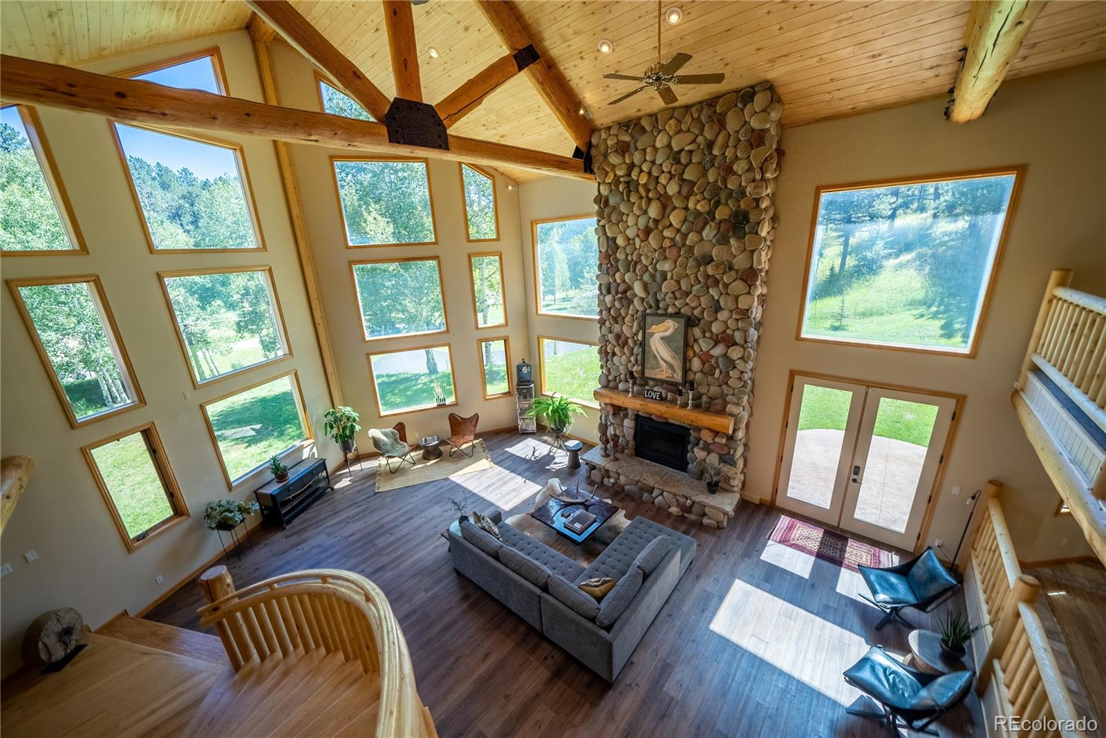 417 Witter Gulch Road Evergreen, CO 80439 - Photo 12 of 39 a living room with furniture large window and wooden floor
