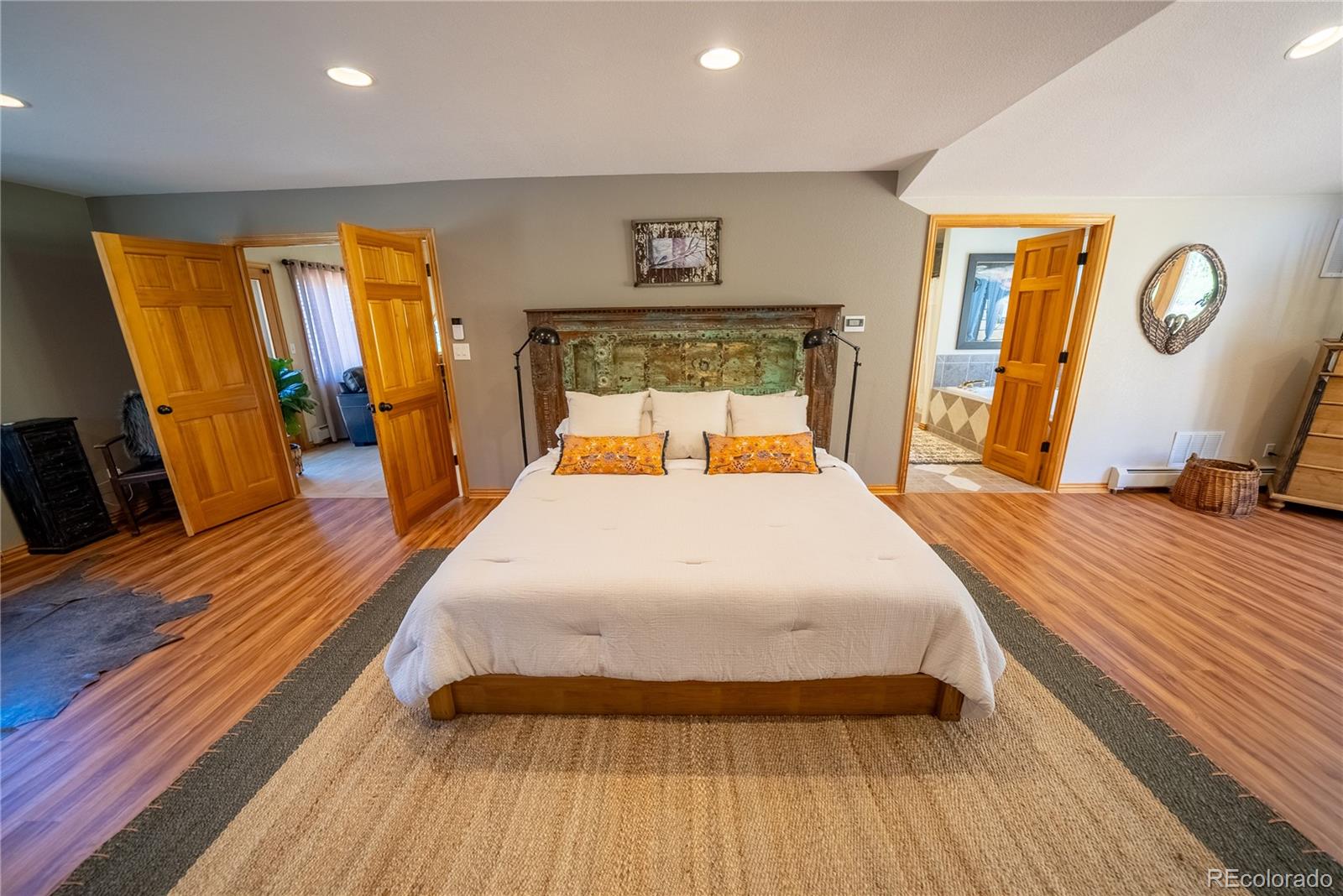 417 Witter Gulch Road Evergreen, CO 80439 - Photo 15 of 39 a large bedroom with wooden floor and a bed