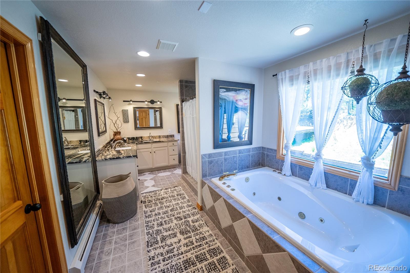 417 Witter Gulch Road Evergreen, CO 80439 - Photo 17 of 39 a large kitchen with a refrigerator a sink dishwasher a dining table and chairs with wooden floor