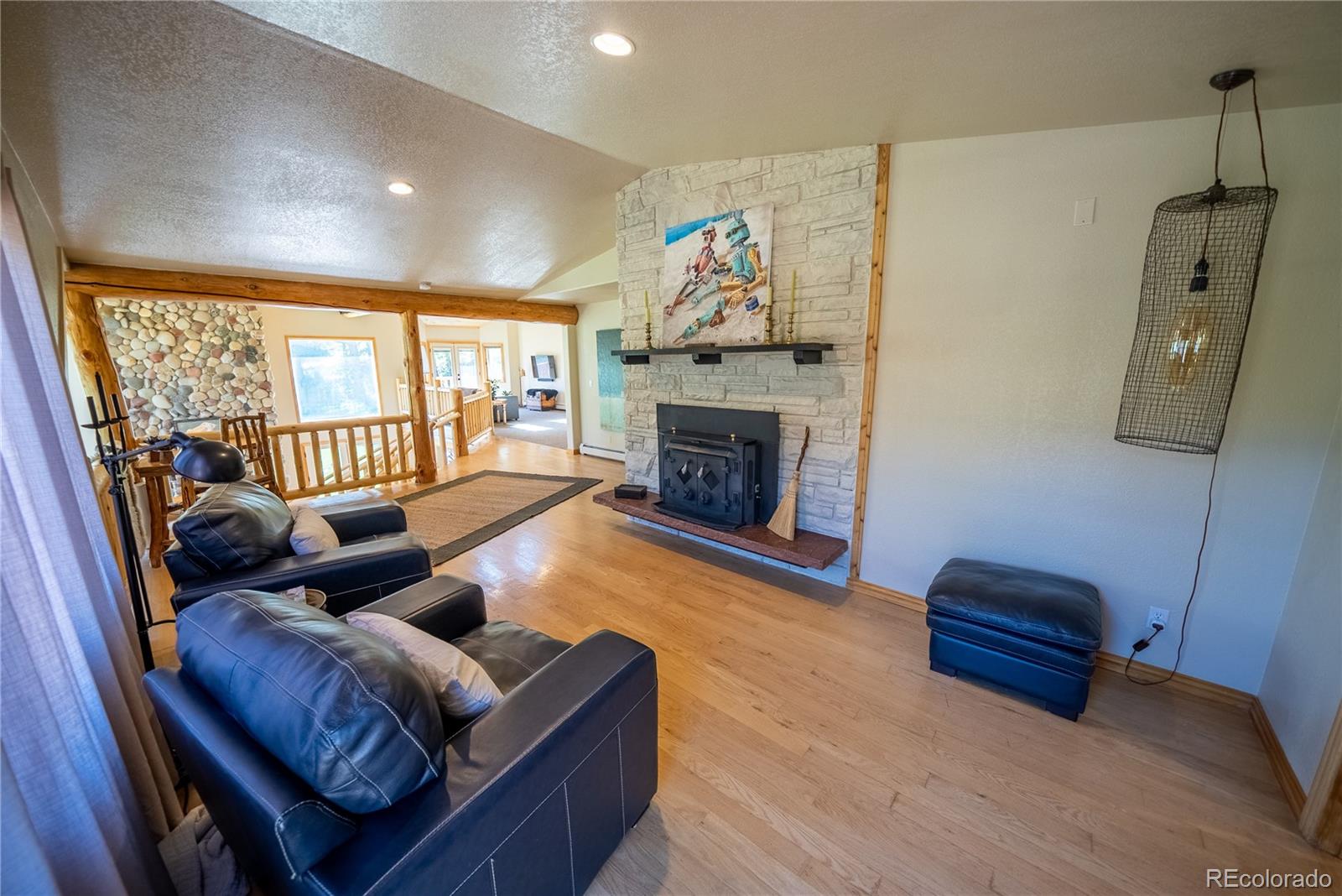 417 Witter Gulch Road Evergreen, CO 80439 - Photo 19 of 39 a living room with furniture and a fireplace