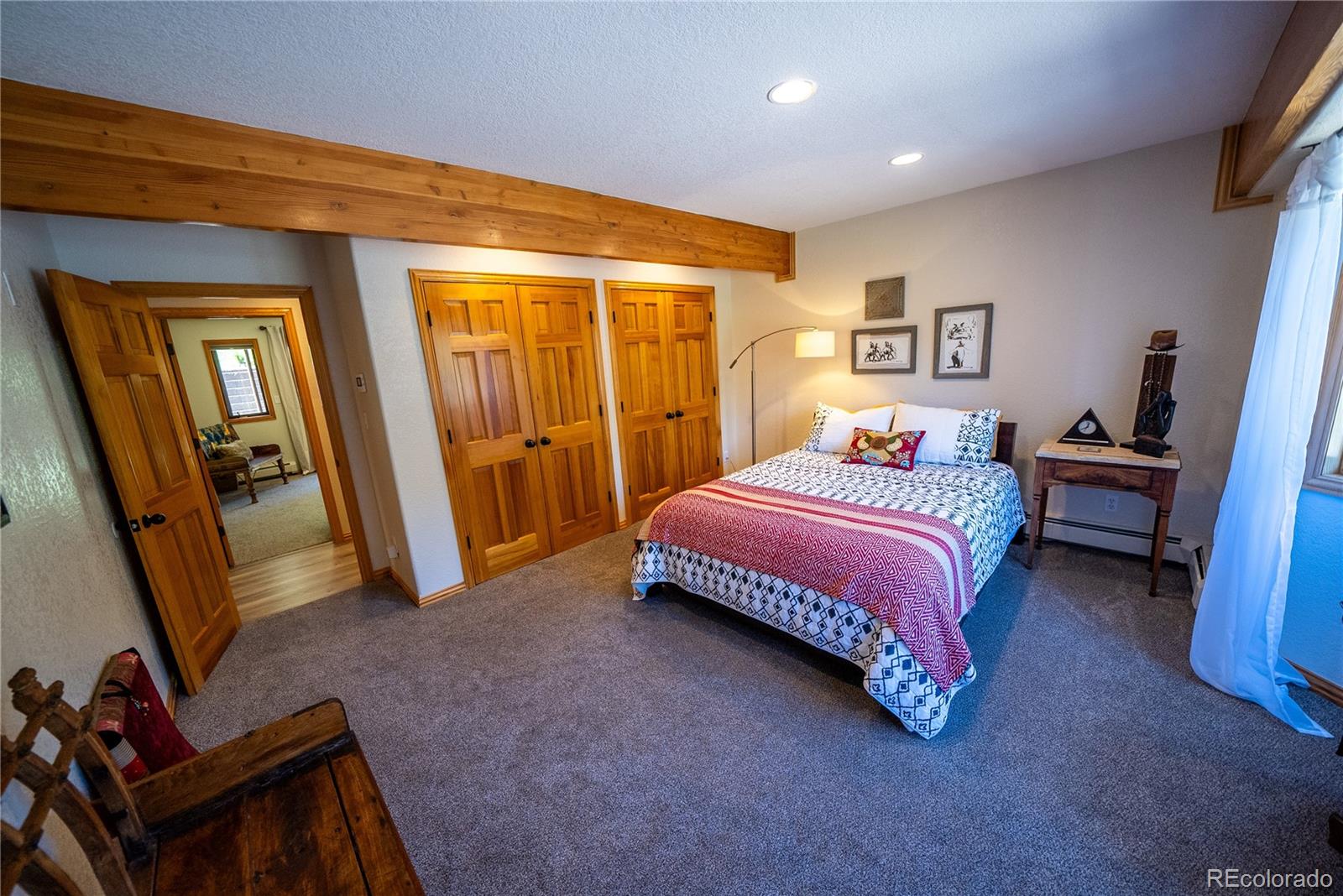 417 Witter Gulch Road Evergreen, CO 80439 - Photo 24 of 39 a bedroom with a bed and a flat tv screen on wall