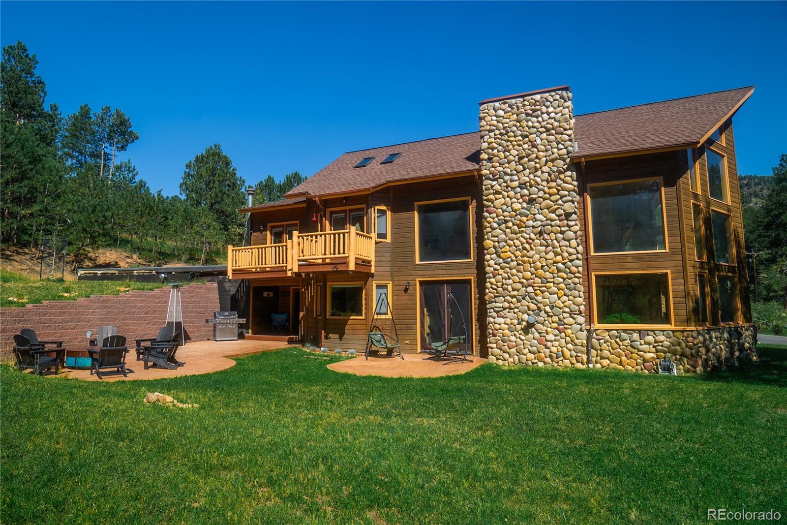 417 Witter Gulch Road Evergreen, CO 80439 - Photo 34 of 39 a front view of a house with a yard table and chairs