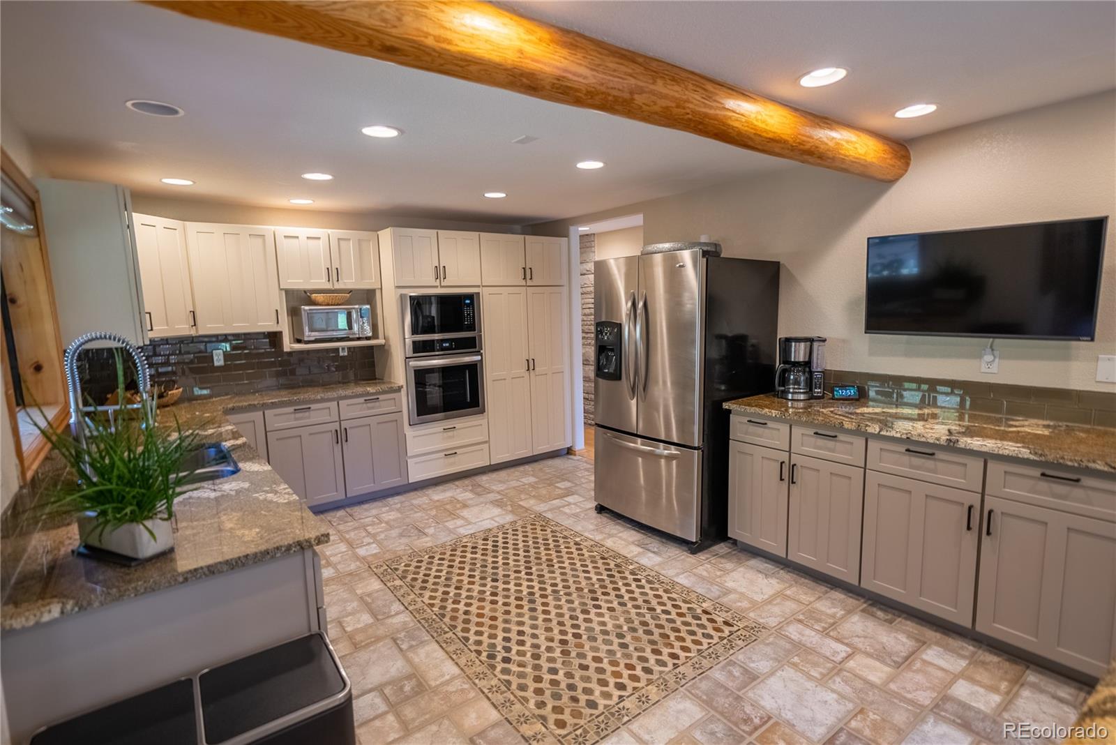 417 Witter Gulch Road Evergreen, CO 80439 - Photo 7 of 39 a kitchen with stainless steel appliances kitchen island granite countertop a refrigerator and a stove top oven
