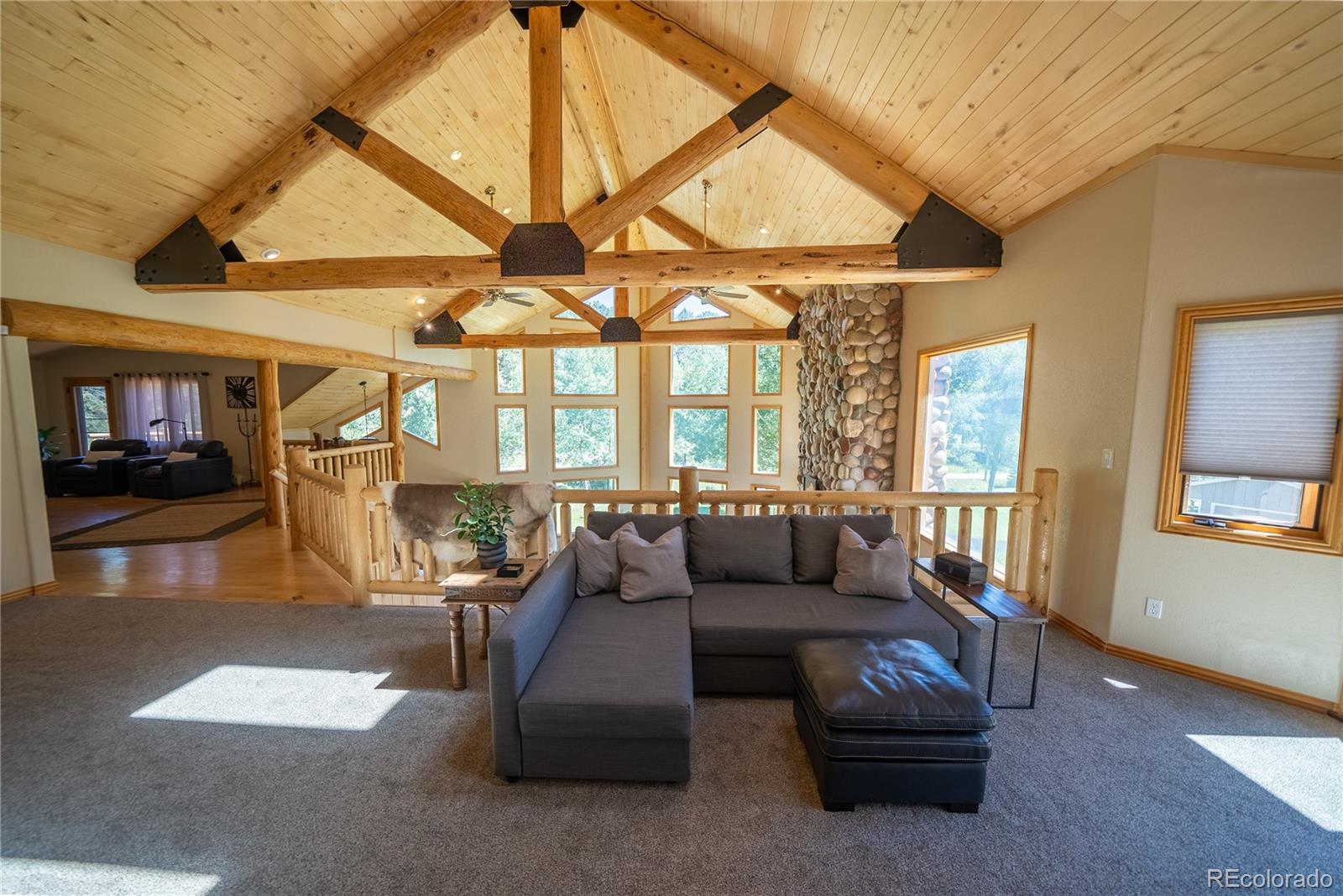 417 Witter Gulch Road Evergreen, CO 80439 - Photo 9 of 39 a living room with furniture and a chandelier