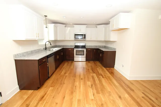 a large kitchen with stainless steel appliances granite countertop a stove a sink dishwasher and a refrigerator