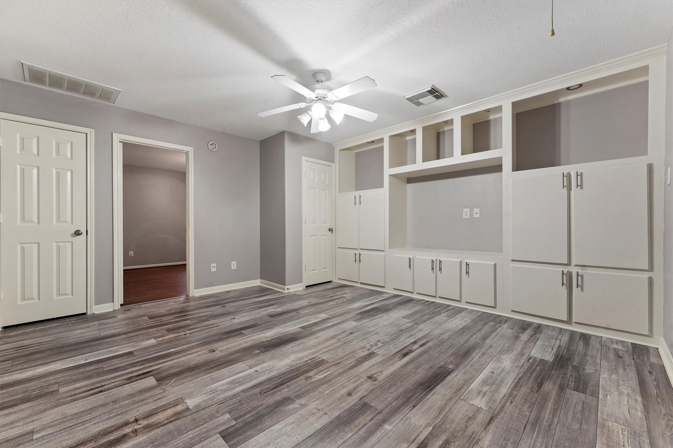 24522 Forest Path Court Spring, TX 77373 - Photo 12 of 18 a view of an empty room with wooden floor and a ceiling fan