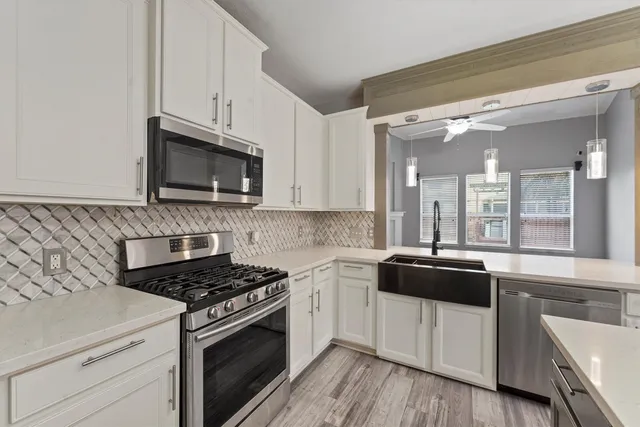 a kitchen with stainless steel appliances a sink a stove and cabinets