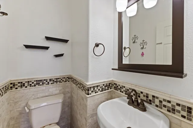 a bathroom with a toilet sink and mirror