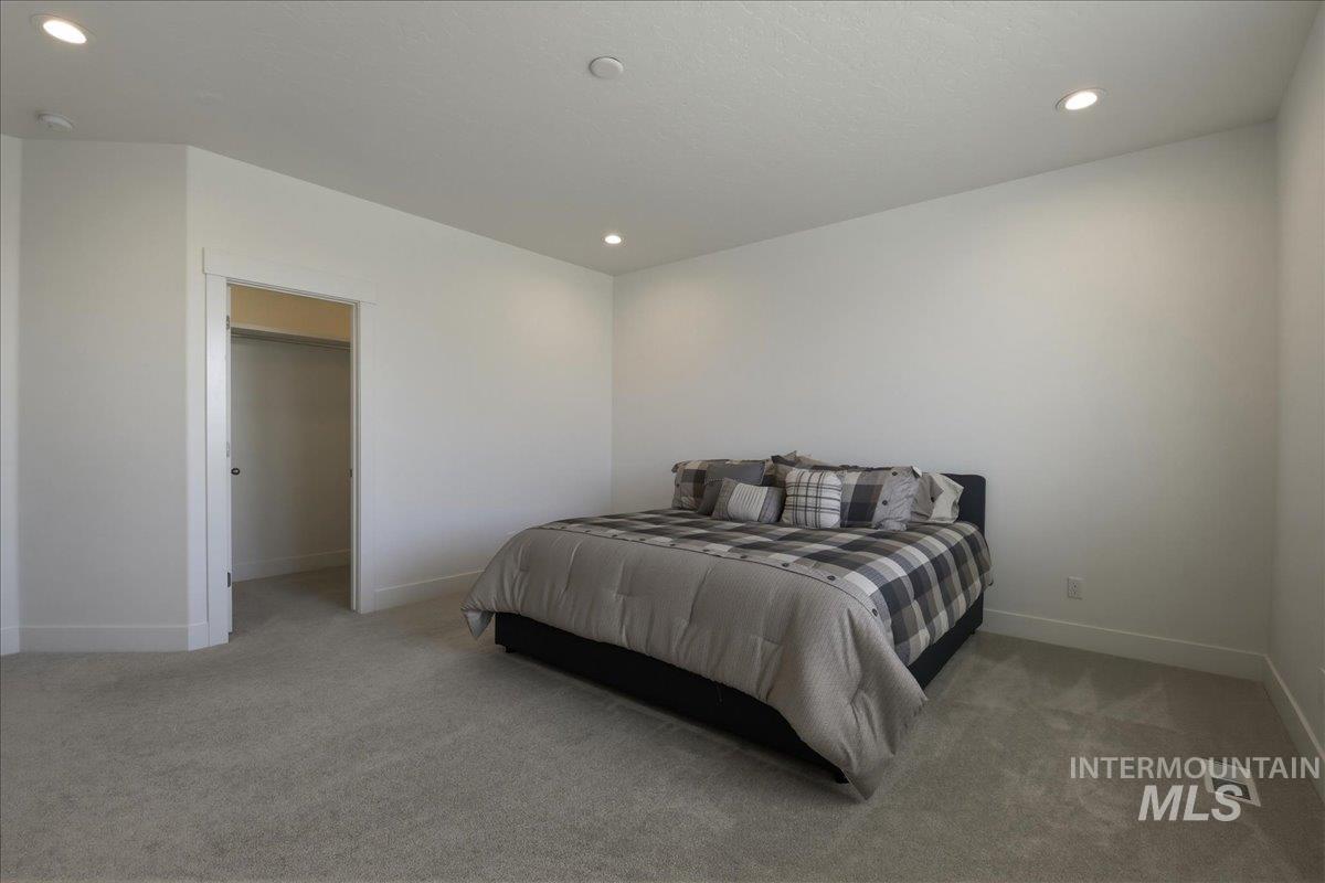 2109 North Gelding Court Middleton, ID 83644 - Photo 20 of 39 Bedroom with a walk in closet, light colored carpet, and recessed lighting