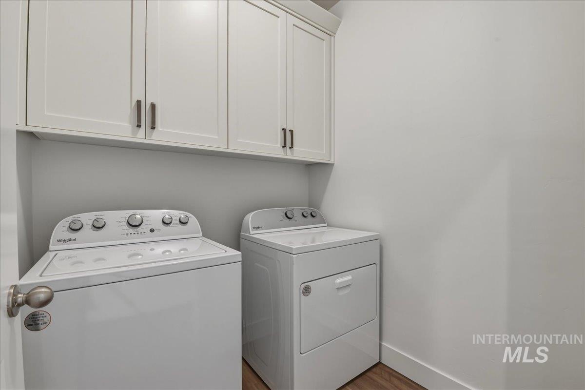 2109 North Gelding Court Middleton, ID 83644 - Photo 28 of 39 Laundry room with included washer and dryer, light wood-style flooring, and cabinet space.