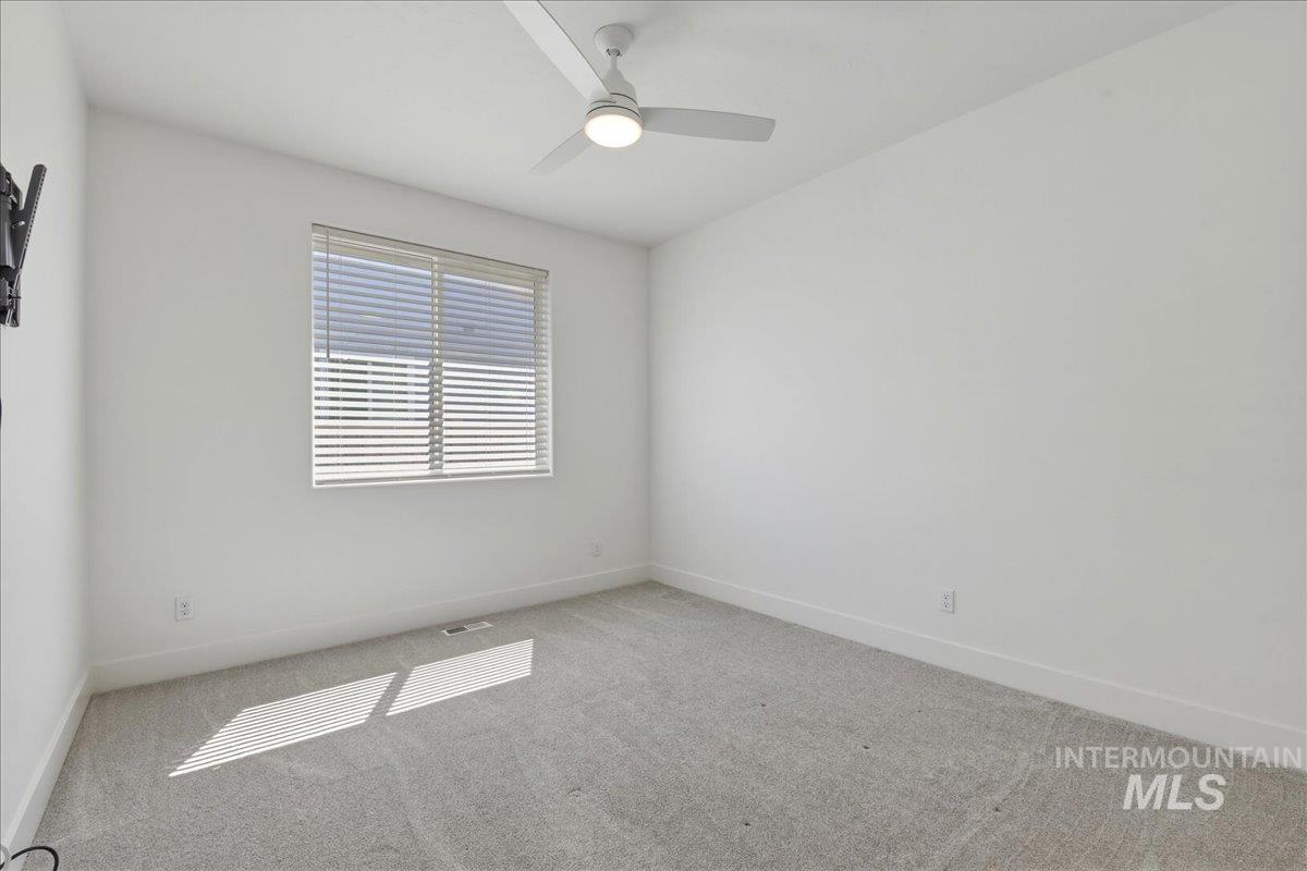 2109 North Gelding Court Middleton, ID 83644 - Photo 30 of 39 Empty room with light colored carpet and ceiling fan