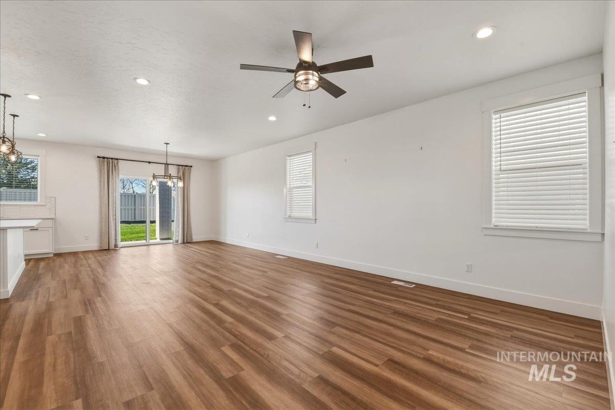 2109 North Gelding Court Middleton, ID 83644 - Photo 8 of 39 Unfurnished living room featuring a ceiling fan, dark wood-style flooring, and a chandelier