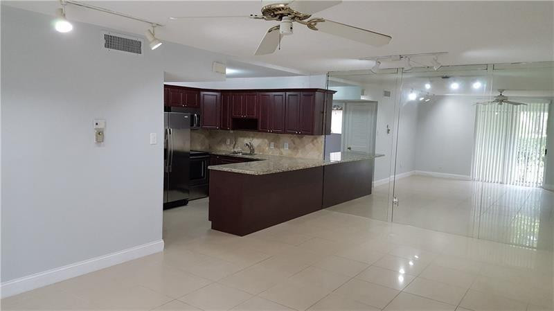 22785 Southwest 66th Avenue, Unit 103 Boca Raton, FL 33428 - Photo 3 of 8 a large kitchen with a large counter top cabinets and stainless steel appliances