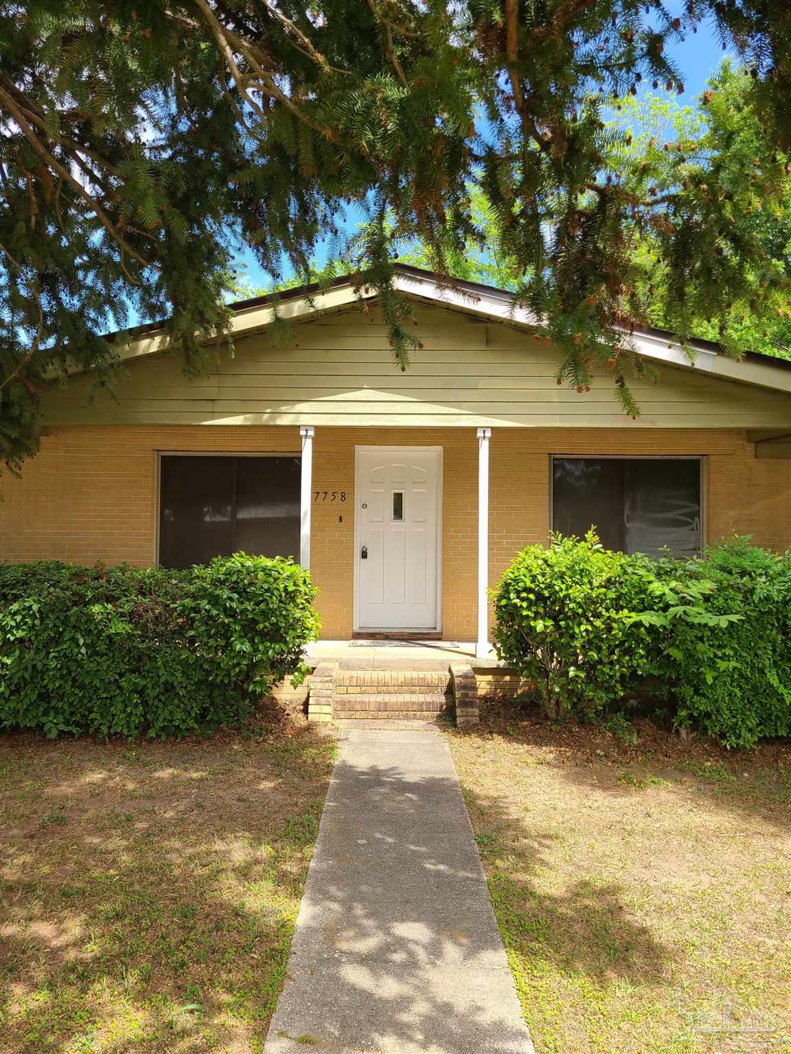 7758 Kipling Street Pensacola, FL 32514 - Photo 1 of 23 a front view of a house with garden