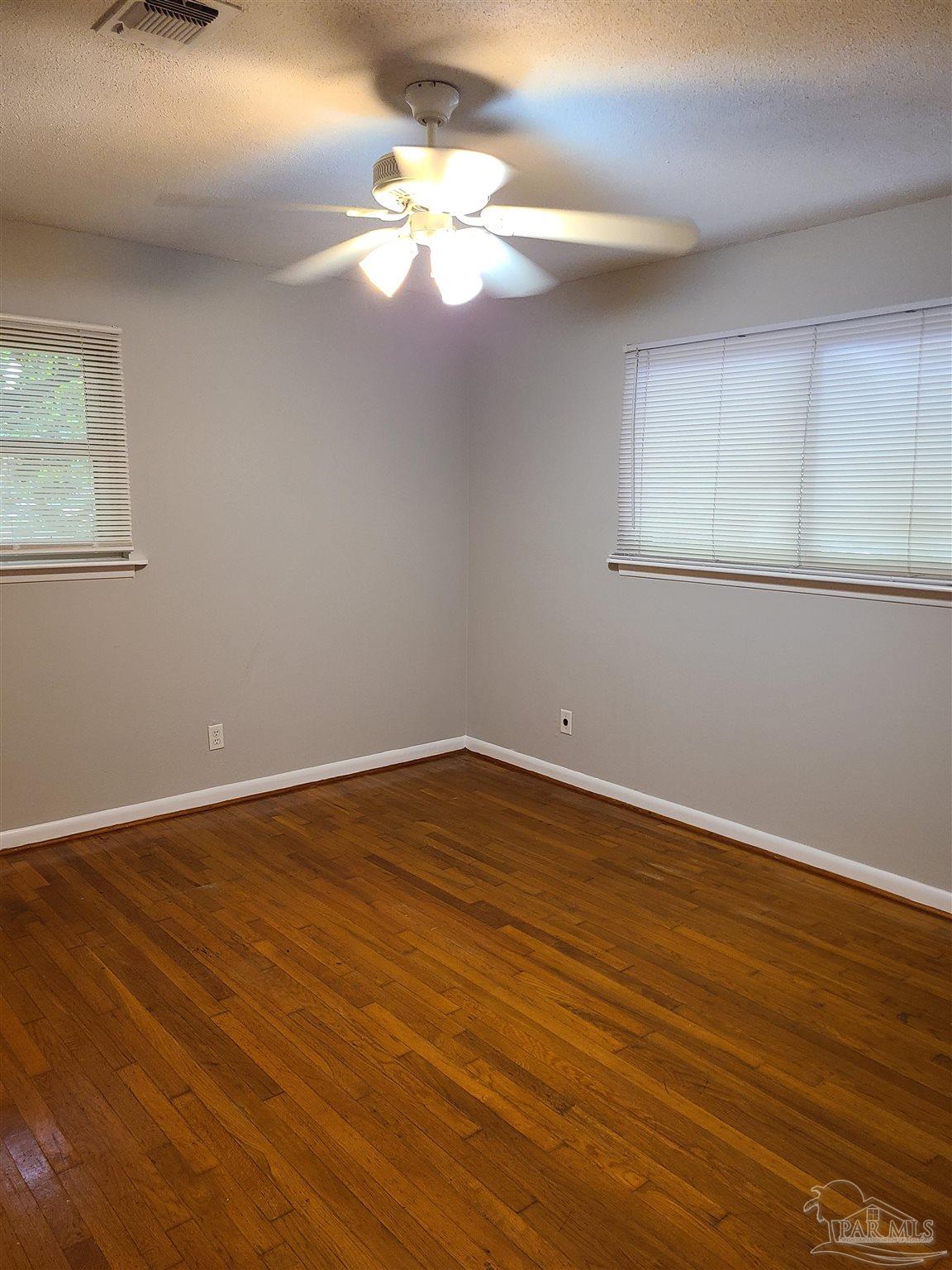 7758 Kipling Street Pensacola, FL 32514 - Photo 13 of 23 a view of an empty room with wooden floor and a window