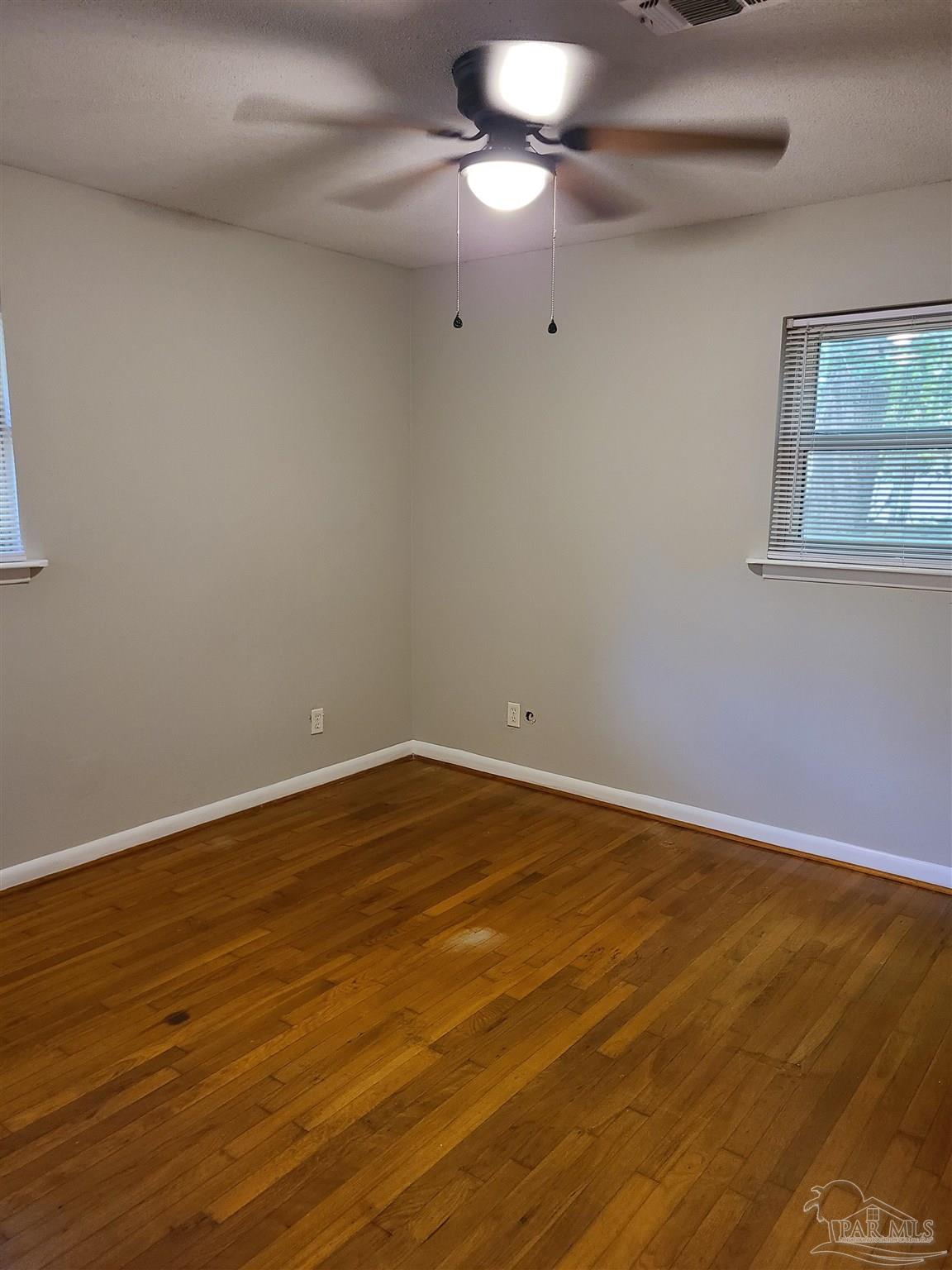 7758 Kipling Street Pensacola, FL 32514 - Photo 14 of 23 a view of an empty room with wooden floor and fan