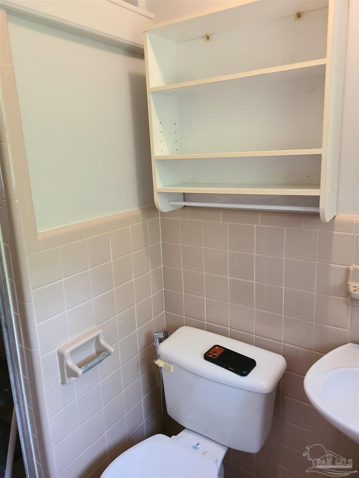 7758 Kipling Street Pensacola, FL 32514 - Photo 16 of 23 a bathroom with a toilet a sink and a mirror